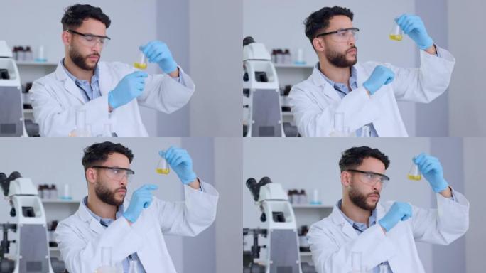严肃的男性科学家在实验室里分析烧杯中的液体。专业的生物化学家测试黄色流体，在医学研究设施中进行实验以