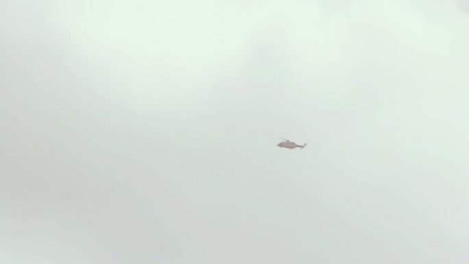救援直升机在多云的天空中飞行，飞越南大西洋福克兰群岛 (马尔维纳斯)。