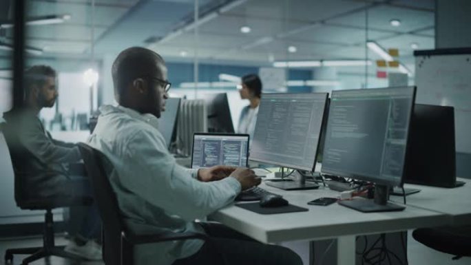 多民族办公室: 在台式电脑上工作的黑色IT程序员。男性专家网站，软件工程师开发应用程序，程序，视频游