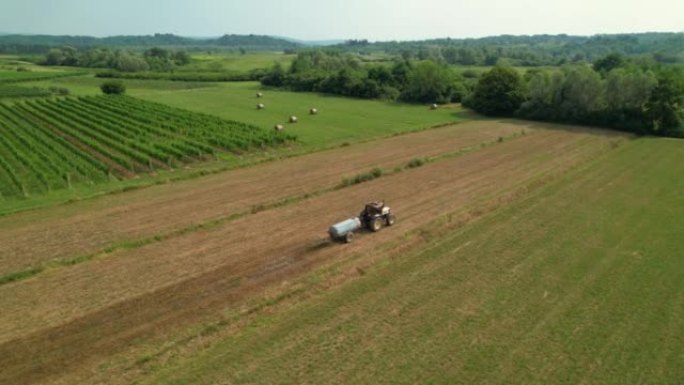 空中: 操作拖拉机的农民为葡萄酒区耕种的农场施肥。
