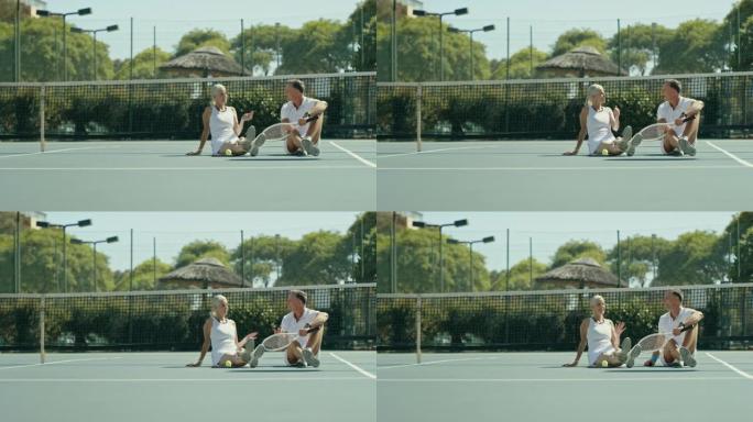 快乐的成熟夫妇一起打网球后坐着说话