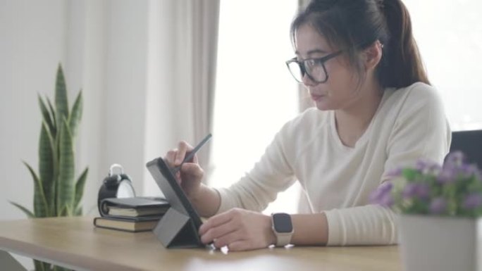 年轻女子在家在客厅放松，使用数字平板电脑