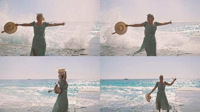 SLO MO女游客在沙滩上旋转，而海浪溅到岩石上