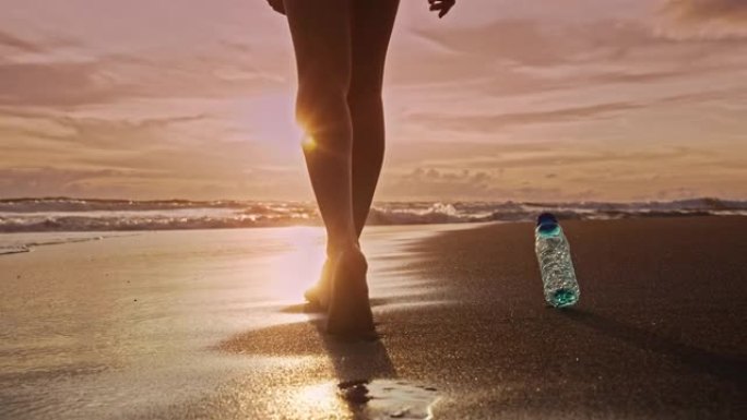 女人用塑料瓶特写行走对海滩自然和海水的环境污染。女孩丢弃的危险垃圾。全球垃圾对海岸和热带沙地的危险