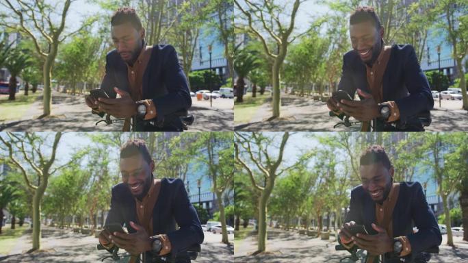 微笑的非洲裔美国商人使用智能手机倚靠自行车