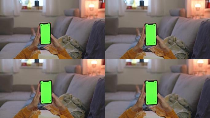 DS无法识别的女人在家中躺在沙发上时使用带有色度键屏幕的智能手机