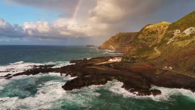 葡萄牙亚速尔群岛圣米格尔岛最西端的海角-蓬塔·达·费拉里亚的鸟瞰图。棕色岩石，大西洋和天空中的彩虹