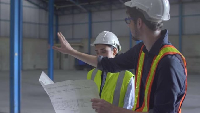 两名工程师建筑师站在大楼里，一边交谈，一边检查施工细节