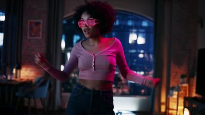 多民族年轻拉丁女性的肖像在未来的霓虹灯发光眼镜中跳舞，在阁楼公寓的家中举行派对。为社交媒体录制有趣的