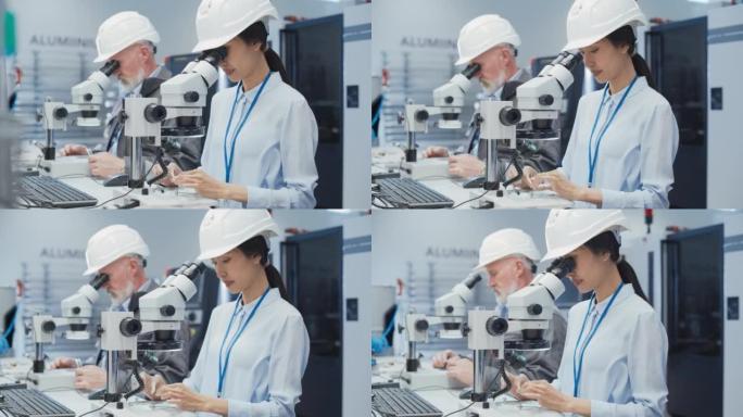 现代技术概念: 两位科学家通过显微镜检查小型工业设备零件。技术人员测试新工厂组件的质量。