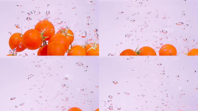 水下: 红色的小番茄掉落并溅入冰冷的淡水中