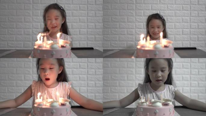 女孩在生日那天在生日蛋糕上吹蜡烛