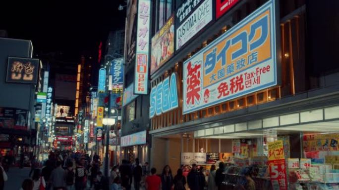 歌舞伎町娱乐和红灯区拥挤的人群以及旅游和商业标志。日本新宿东京晚上。