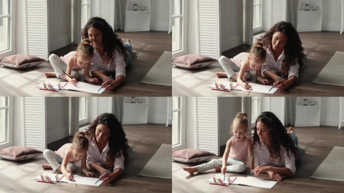 爱心母亲小女儿使用铅笔在相册中着色图片