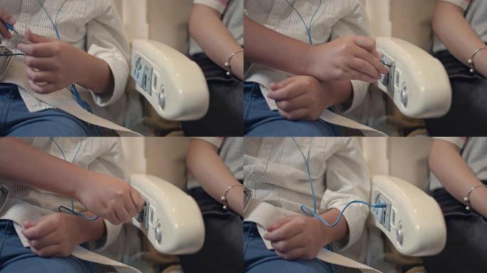 亚洲男孩插入耳机插孔，在飞机上听音乐。
