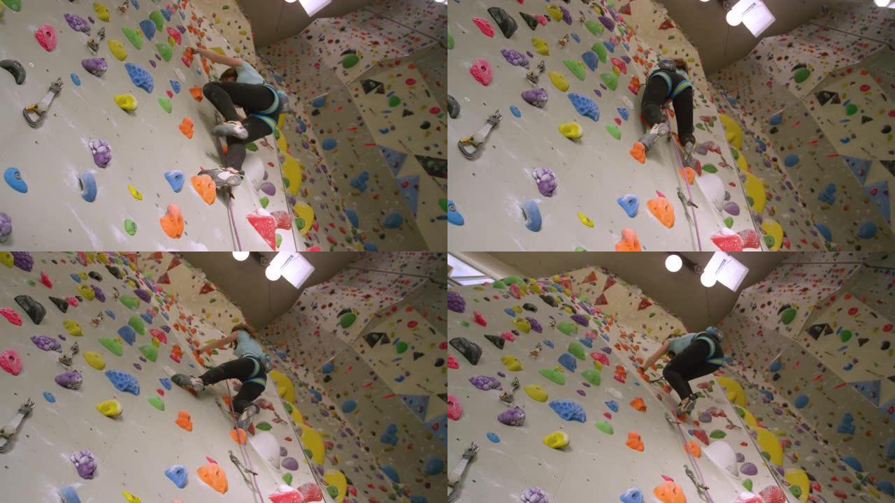自下而上: 十几岁的登山者爬上充满色彩缤纷的室内墙壁。