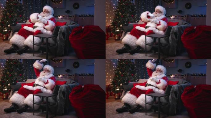 圣诞老人坐在装饰精美的客厅里过圣诞节，坐在灰色的沙发上看电视，吃着爆米花。圣诞老人热情地将爆米花倒入