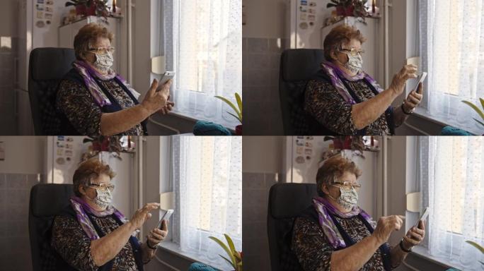 沮丧的老妇在家庭检疫期间戴着防护口罩并使用手机