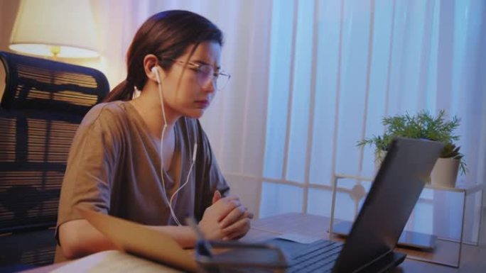 亚洲女商人视频会议关于夜间在家工作的笔记本电脑的会议。