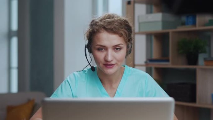医生妇女支持在在线诊所的笔记本电脑上进行视频通话。女医师在视频会议上咨询远程人员。一位聪明的护士在晚