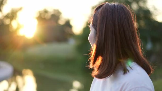 面对女人的积极思考和希望，并希望在公园的早晨日出