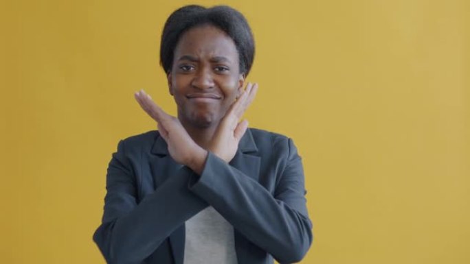非裔美国女士的肖像摇头和手势表示对黄色背景的分歧