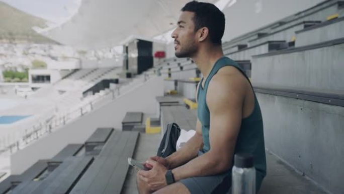 一个年轻人在体育场使用智能手机的4k视频片段