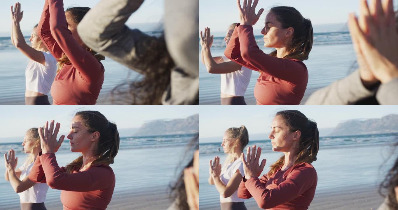一群在海滩上练习瑜伽的女性朋友