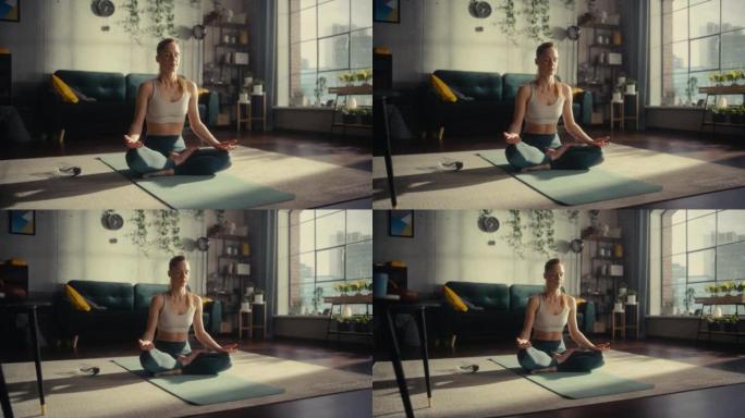 年轻美丽的女性锻炼身体，早上在她阳光明媚的阁楼公寓里练习冥想。健康的生活方式、健身、幸福和正念概念。