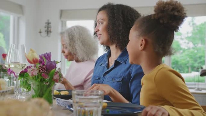 祖母与母亲和孙女在家里享受多代家庭餐