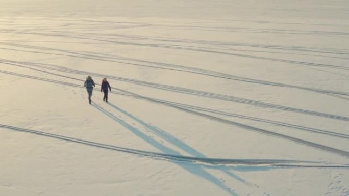 两人背着背包走过雪场