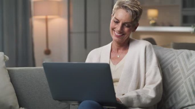 一名高级妇女坐在家里使用笔记本电脑的4k视频片段