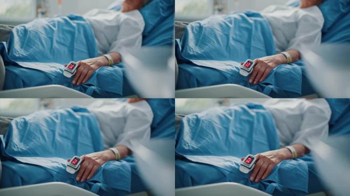 医院病房: 老年妇女躺在床上，手指心率监测器/脉搏血氧仪显示脉搏。她脆弱的手搁在毯子上。专注于手。情