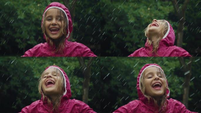 一个穿着粉红色雨衣的快乐小女孩在雨中快乐地站着，被大自然和树木包围着。女孩微笑着，在雨天独自在外面玩