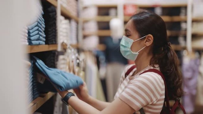 亚洲妇女在布店购物时戴口罩