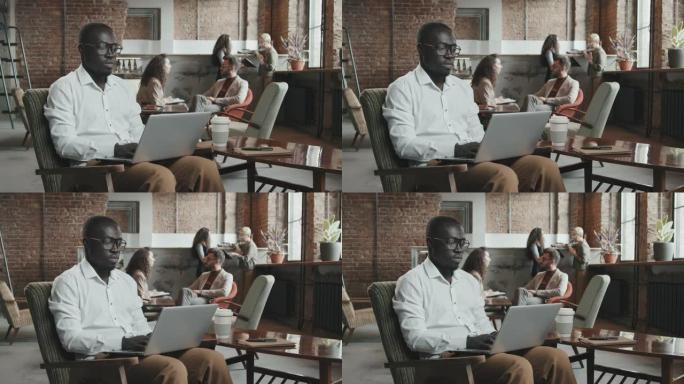 在办公办公室工作的非裔美国人在笔记本电脑上工作
