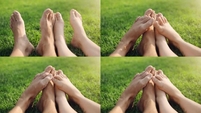 4k视频片段，一对无法识别的夫妇在公园的草地上放松时互相摩擦脚