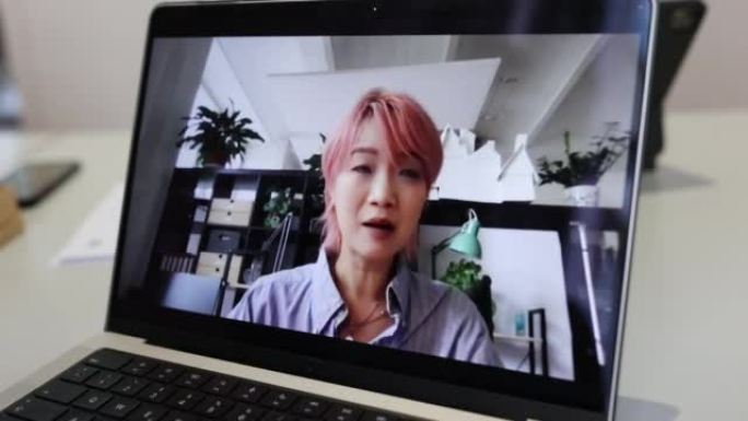 在笔记本电脑屏幕上看到有视频通话的亚洲妇女