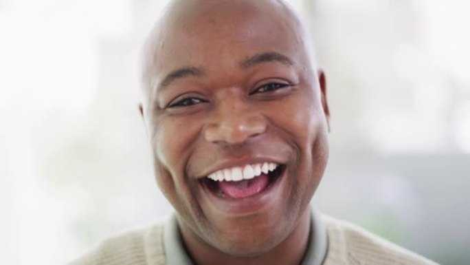 一个成熟的非洲裔美国人的脸微笑着笑着，同时露出完美无瑕的洁白牙齿的肖像。一个快乐，英俊的黑人男子在嘲
