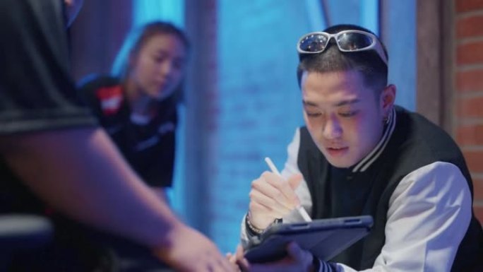 年轻的亚洲男教练在电子竞技比赛中向团队提供指导