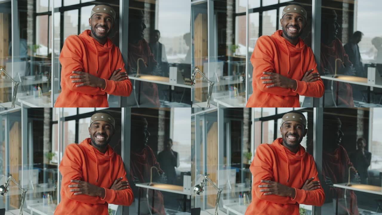 快乐的非洲裔美国男子在创意玻璃墙办公室微笑的慢动作肖像