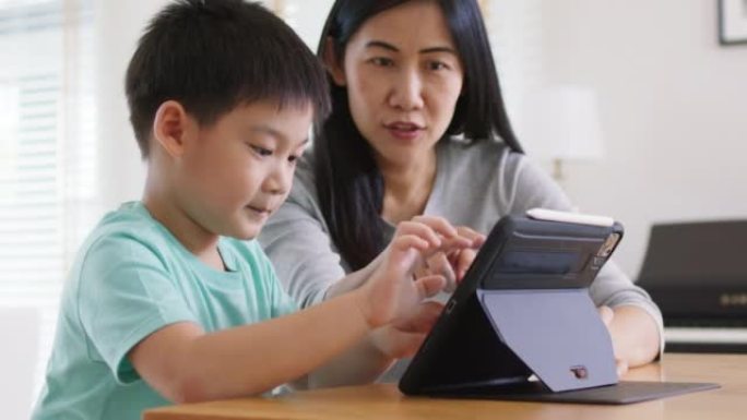 孩子和妈妈享受周末活动在家一起在线玩游戏。