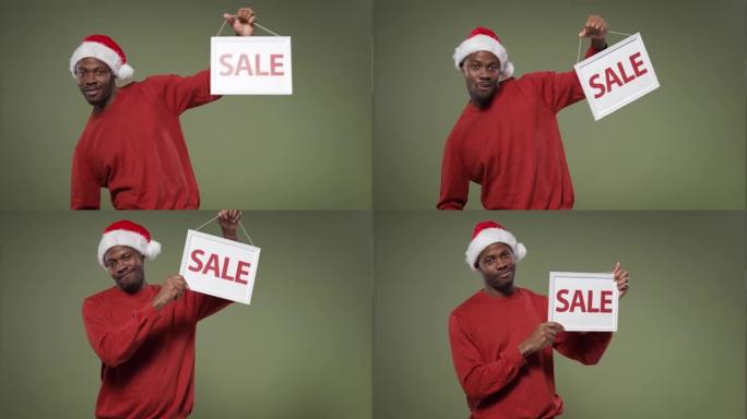 一个穿着鲜红色毛衣和圣诞帽的黑皮肤男人举着 “出售” 标志，微笑着
