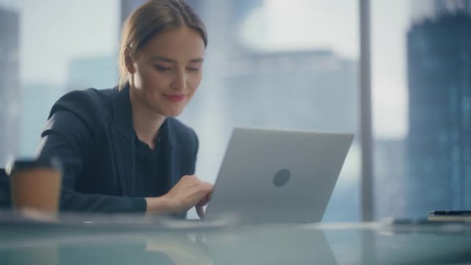 在开放式办公室中，一位美丽的女商人在笔记本电脑上工作的低角度肖像，自信的女首席执行官分析财务项目。经