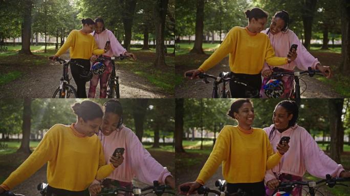 慢动作，两名成年成年女性在郁郁葱葱的绿色森林中自拍，旁边有自行车