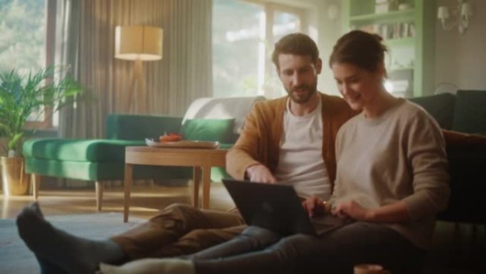 夫妇坐在公寓的客厅地板上使用笔记本电脑。男女朋友聊天，在网上购物，选择在线订购的产品，观看流媒体服务