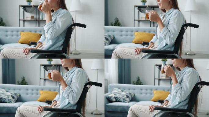年轻的残疾女士独自坐在轮椅上喝茶的肖像