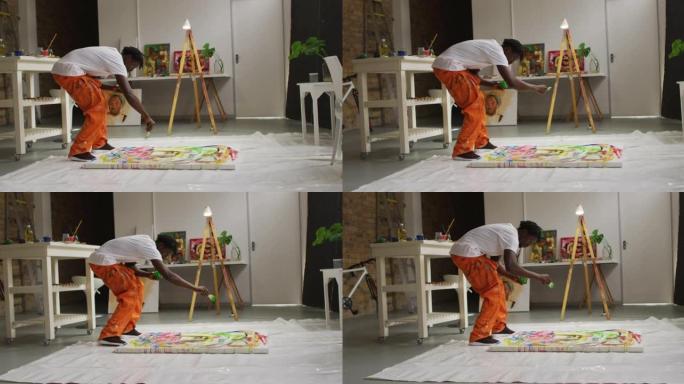 非裔美国男艺术家在艺术工作室用画笔在画布上倒油漆