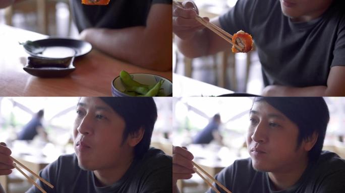 SLO MO年轻人用筷子咀嚼加利福尼亚卷。