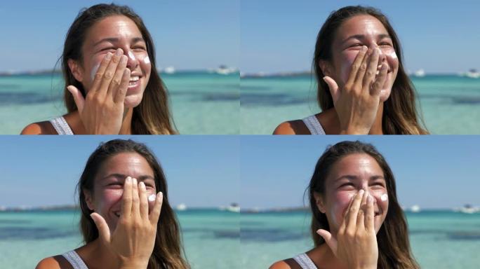 一个年轻漂亮的女人涂防晒霜在沙滩上微笑的肖像。无忧无虑的女性安全晒黑，保护她的皮肤免受紫外线伤害，同